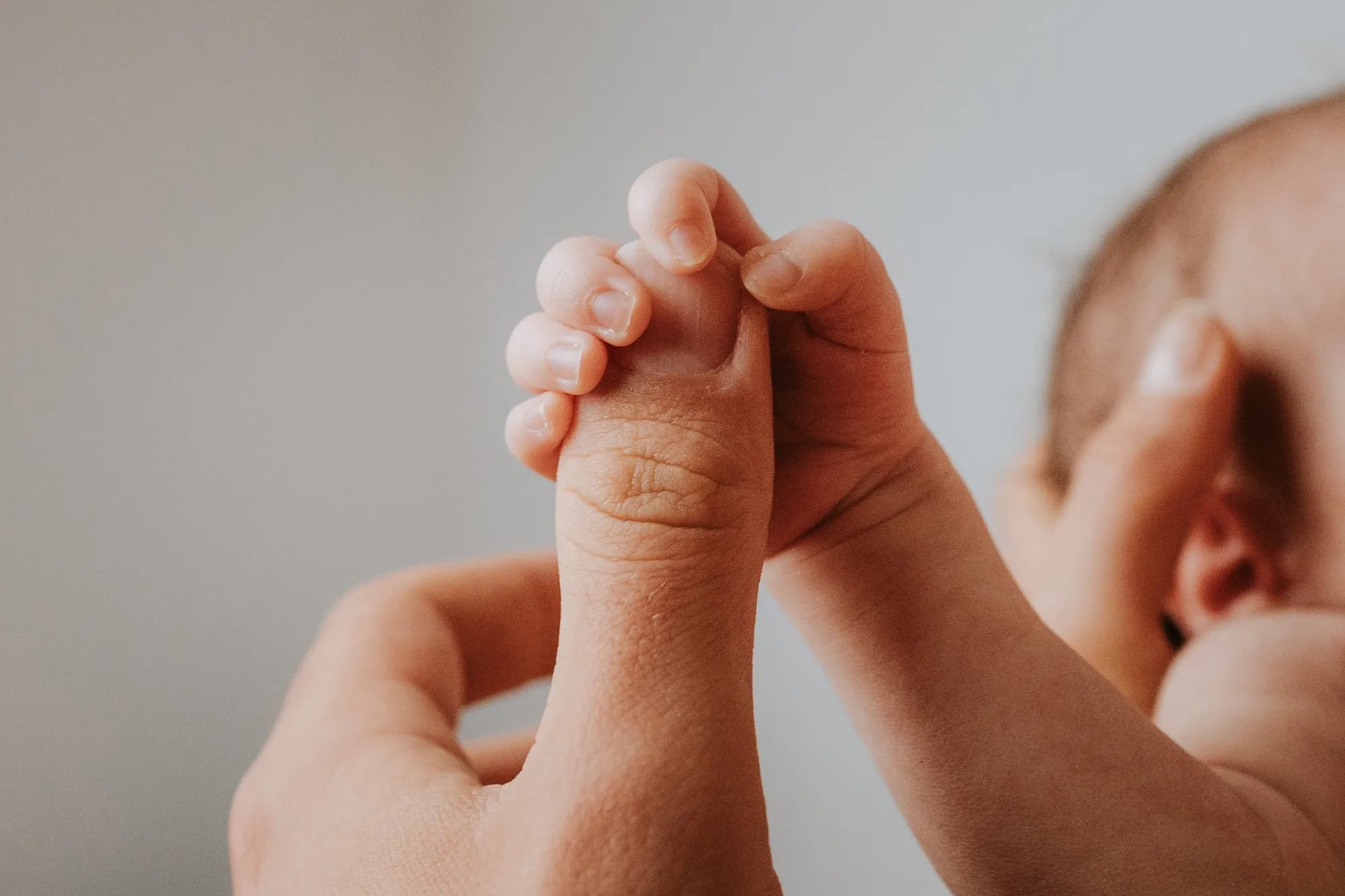 Neugeborenenfotografie Innsbruck – Baby in Elternhänden