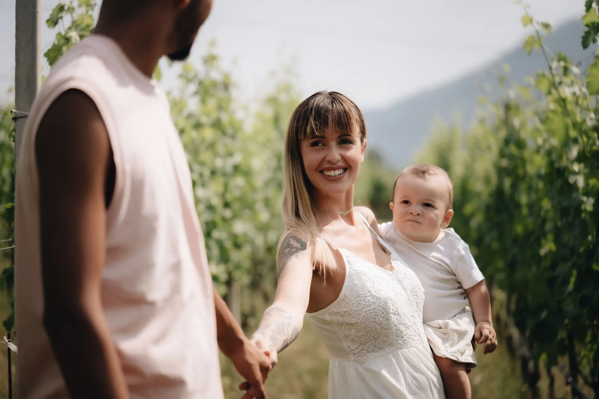 Familienfotograf Tirol – Mama läuft lachend mit ihrem Kind durch den Weinberg