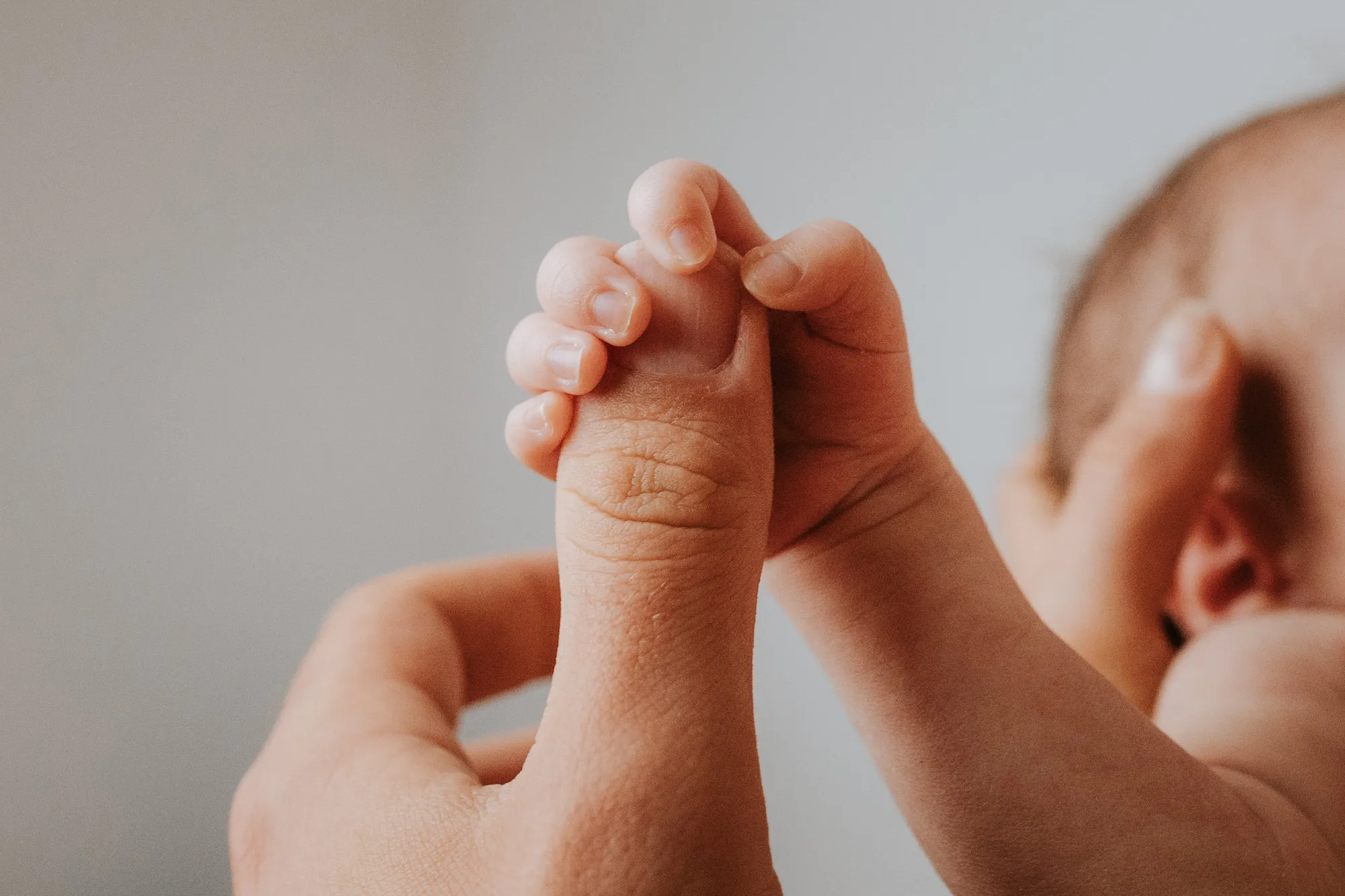 Neugeborenenfotografie Innsbruck – Baby in Elternhänden