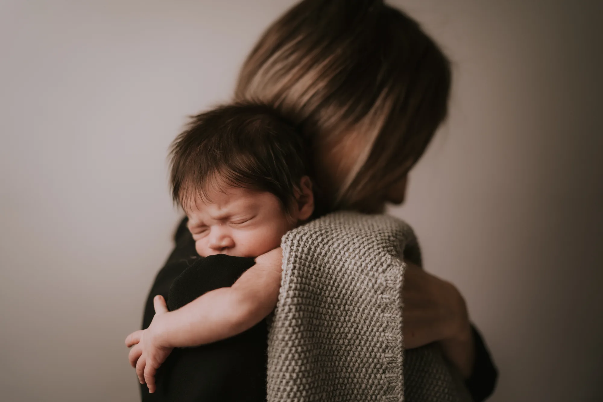 Newborn Shooting Tirol – Neugeborenes kuschelt auf Mamas Schulter