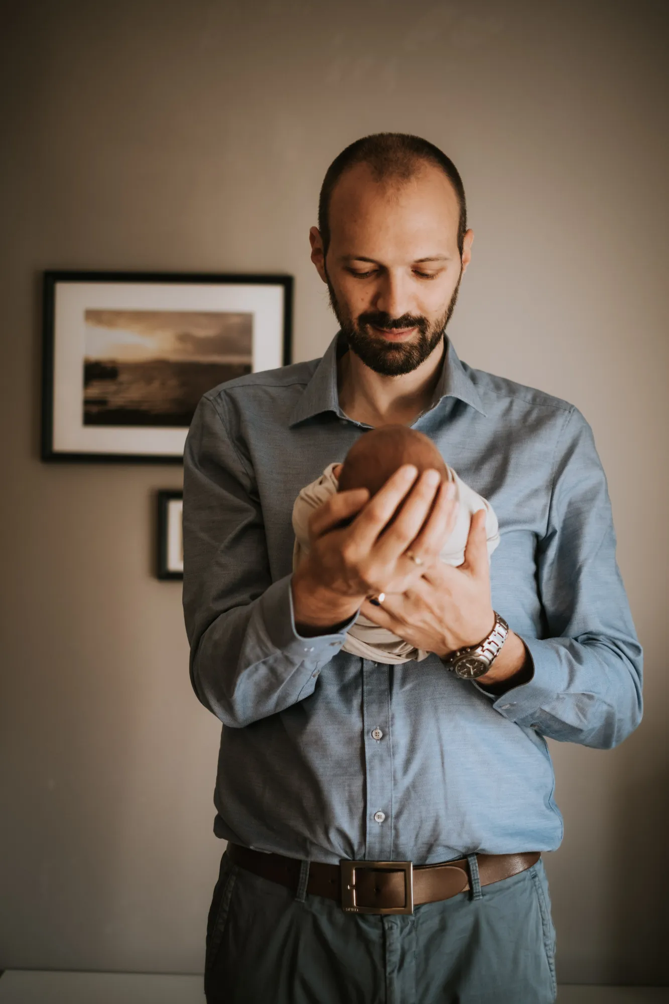 Neugeborenenfotografie Tirol – Papa hält sein Neugeborenes im Arm